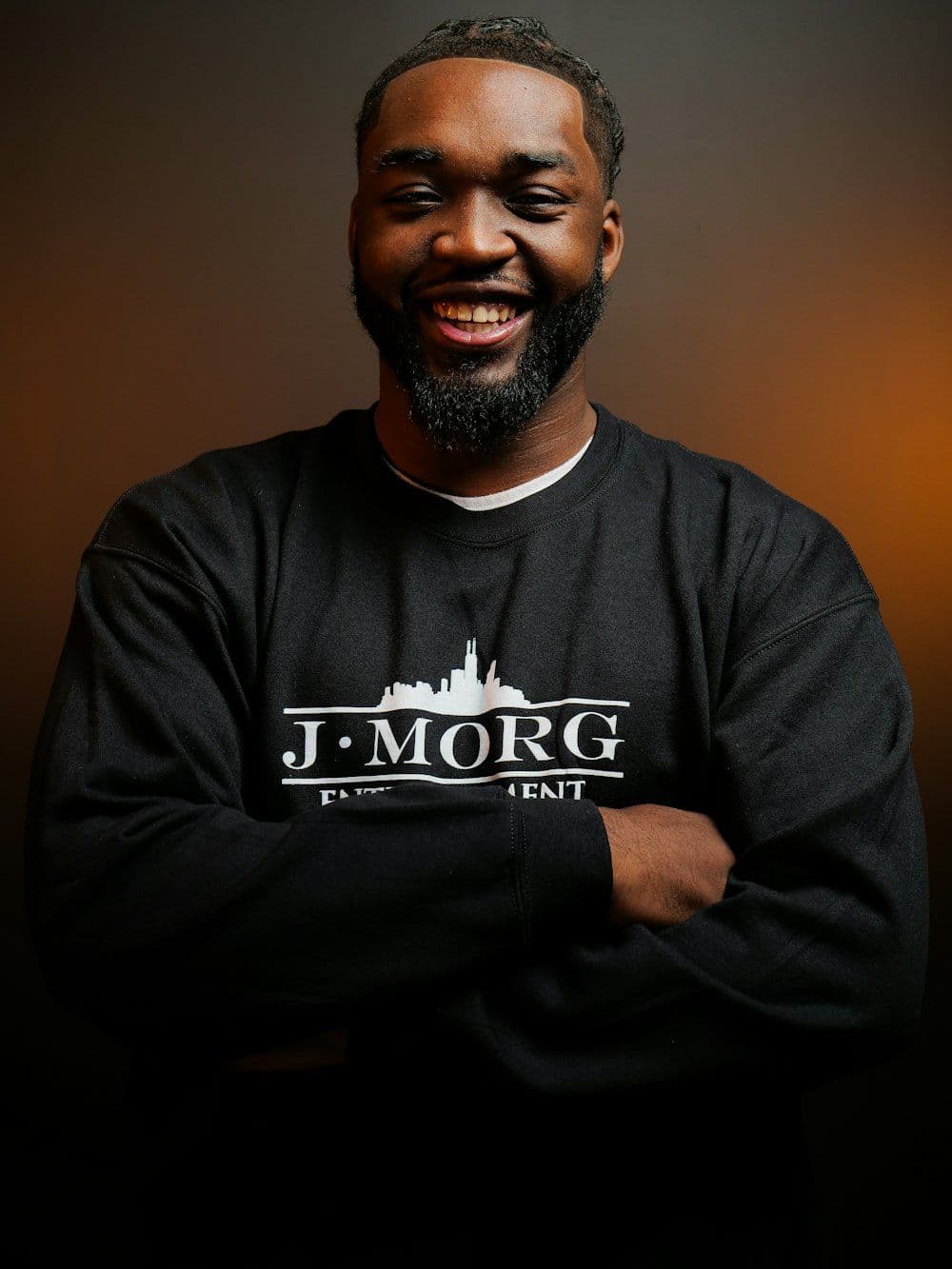 A smiling man in a dark sweatshirt